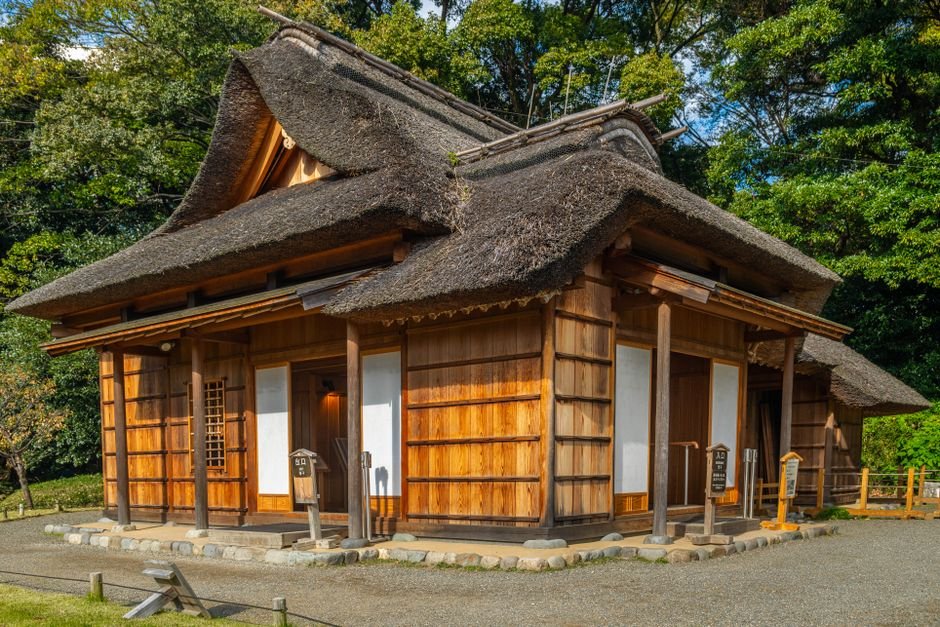 Japonijos sodo jaukus medinis namelis šiaudiniu stogu, primenantis vaikišką